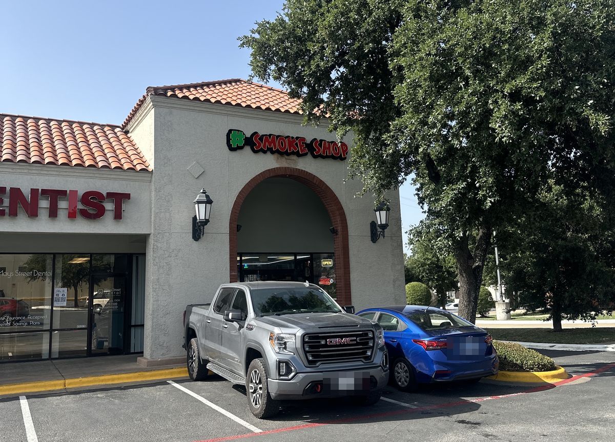 The Hashtag Smoke Shop number 2 storefront beside Mays Street Dental on the Interstate 35 frontage road in Round Rock