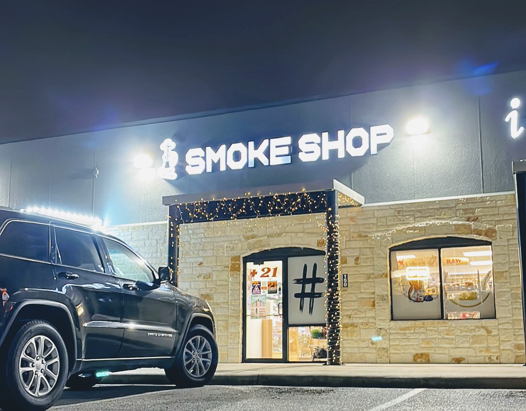 The Hashtag Smoke Shop number 1 storefront lit up at night on East Palm Valley Boulevard in Round Rock